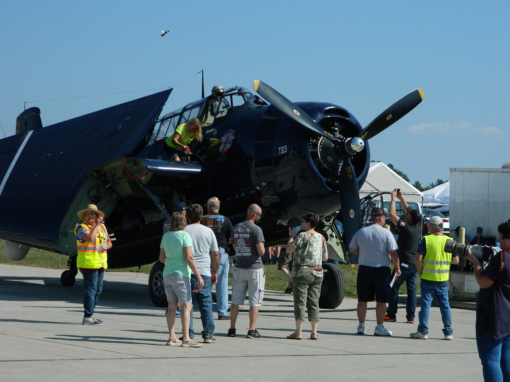 A large Airplane on display surronded by people checking it out